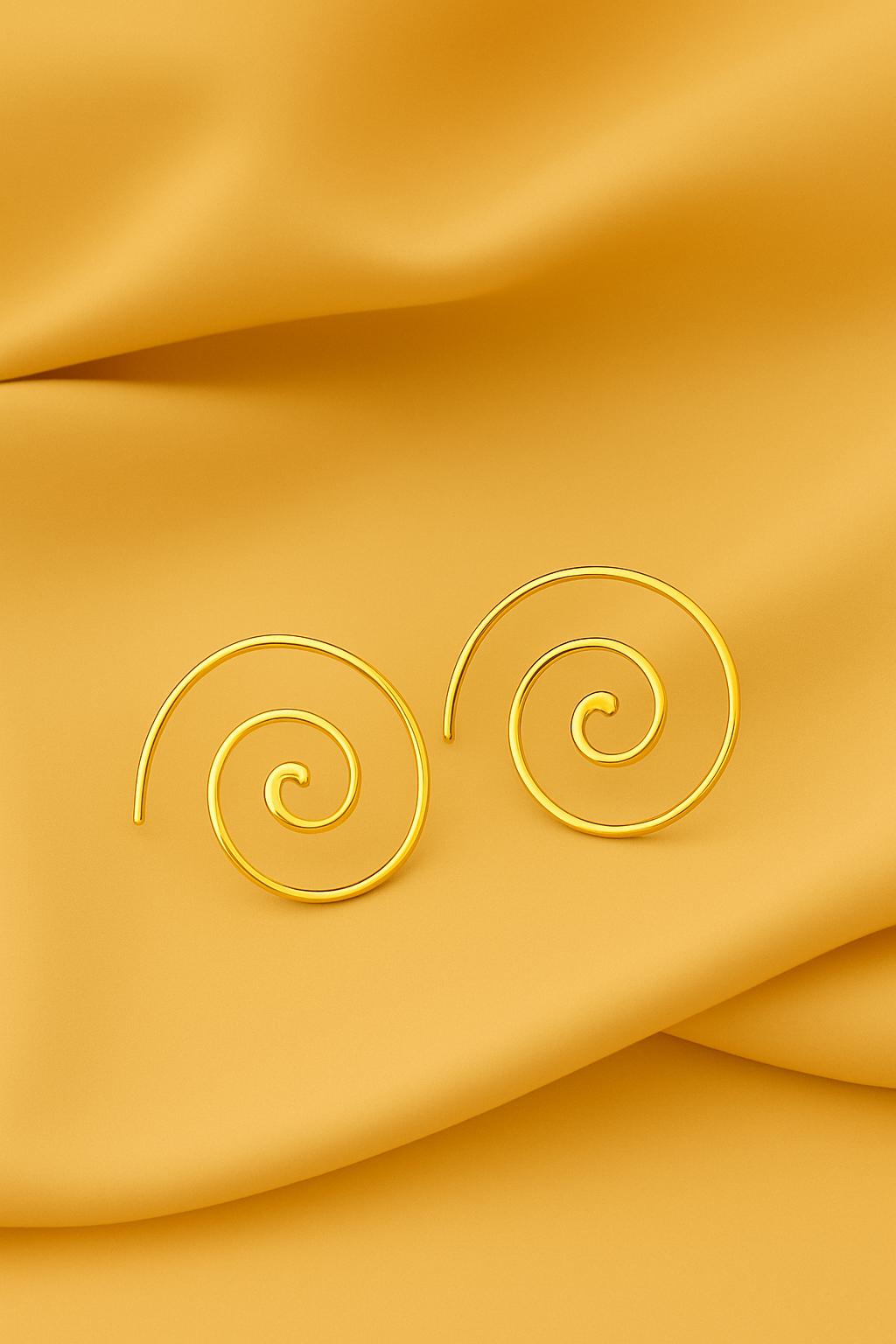 Gold spiral earrings on a yellow fabric background