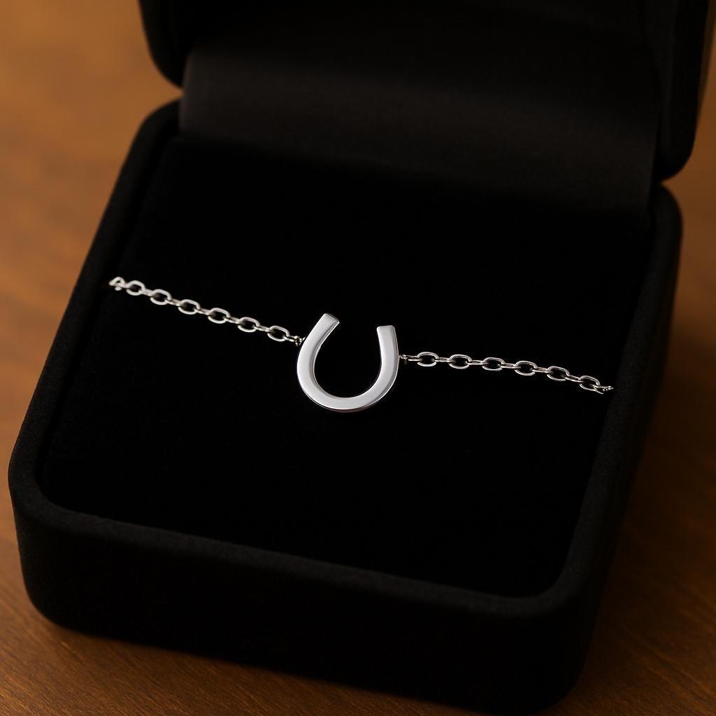 Silver horseshoe bracelet in a black jewelry box on a wooden surface