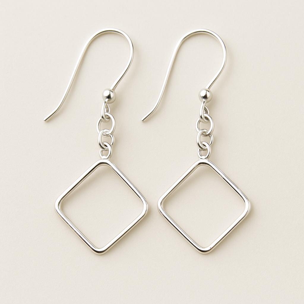 Pair of silver square drop earrings on a light beige background