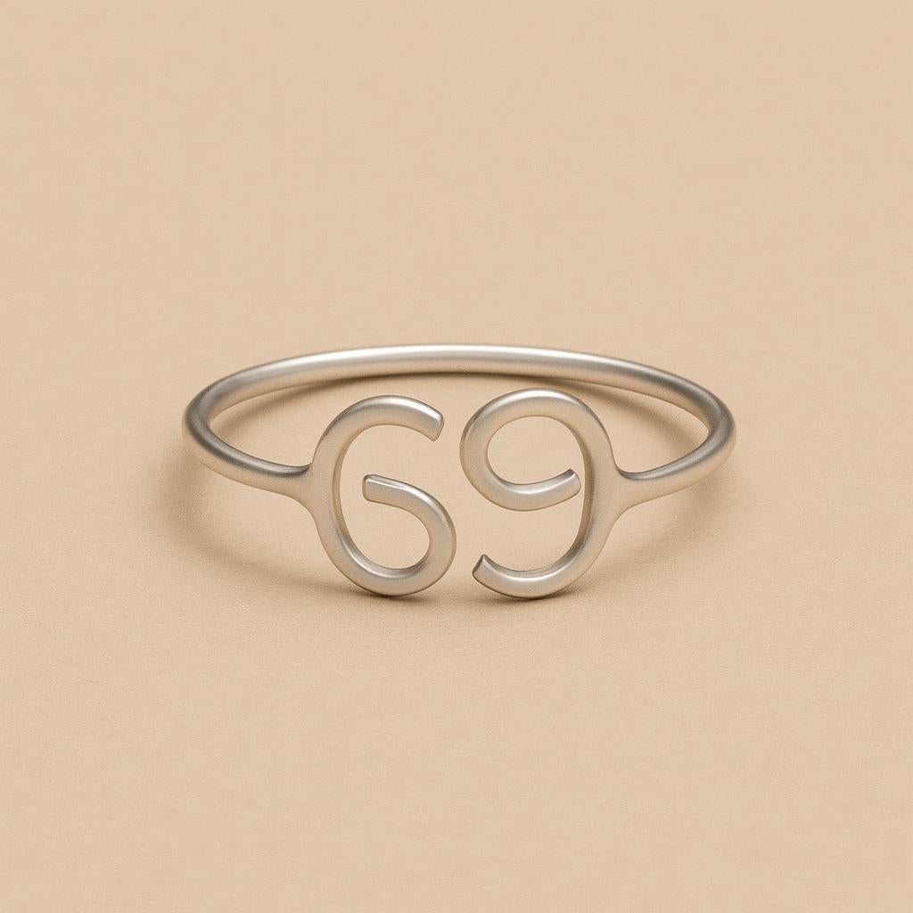 Silver ring with the number '69' on a beige background