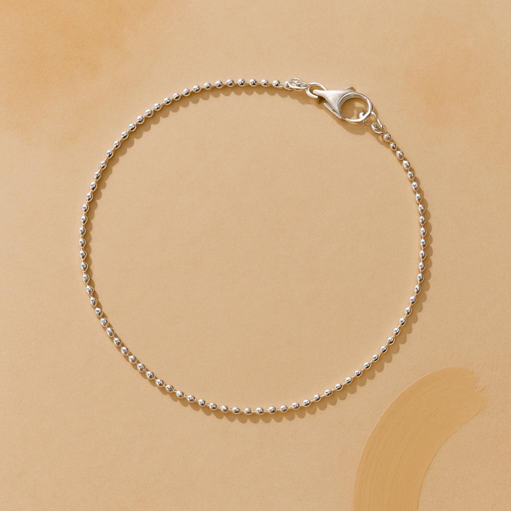 Silver beaded bracelet on a beige background