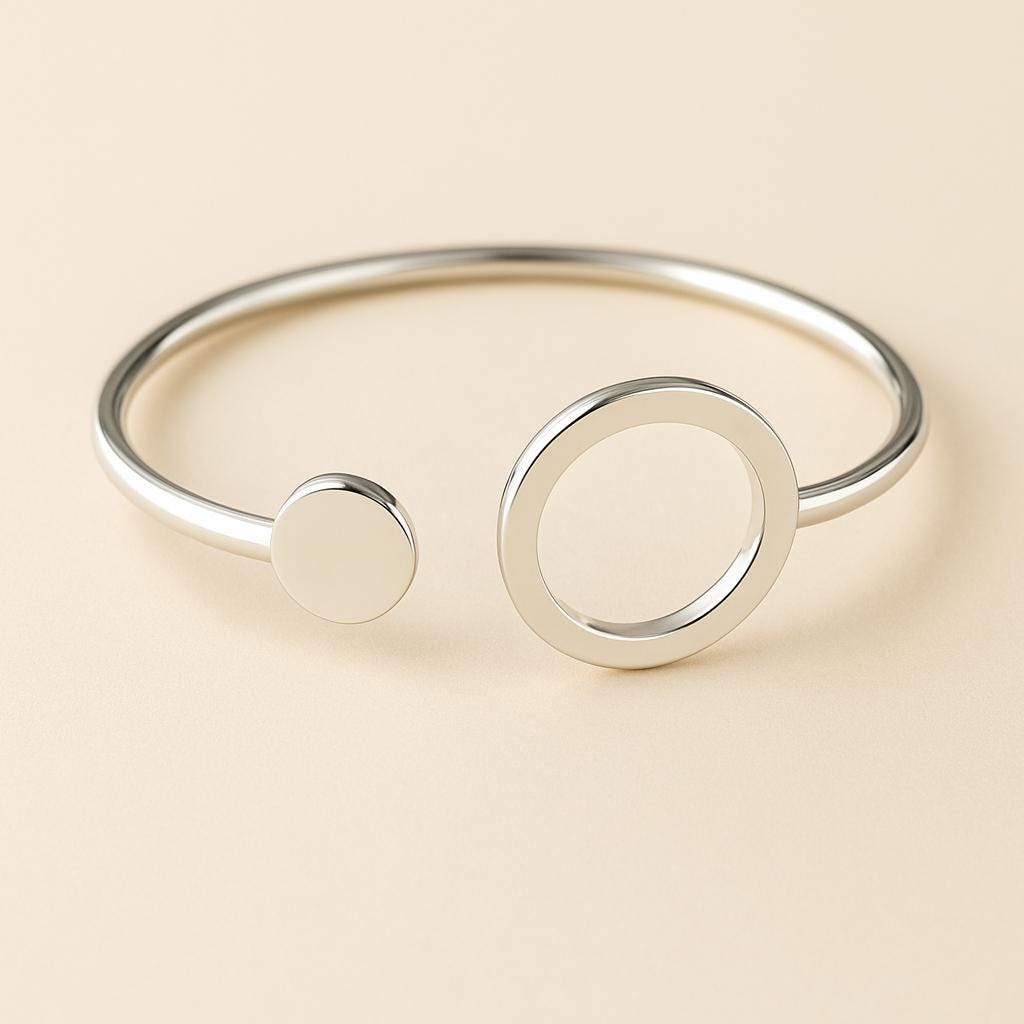 Silver bracelet with circular design on a beige background