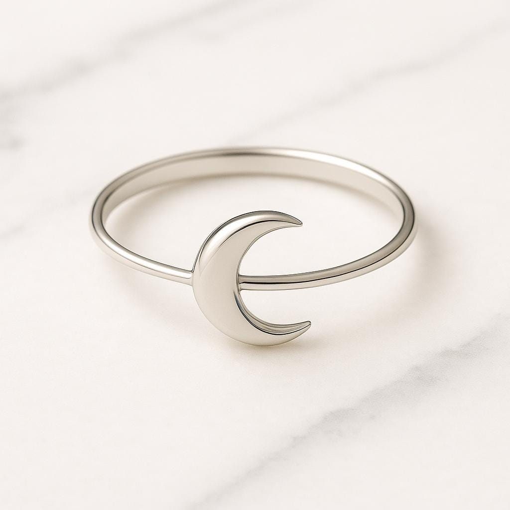 Silver ring with a crescent moon design on a light background