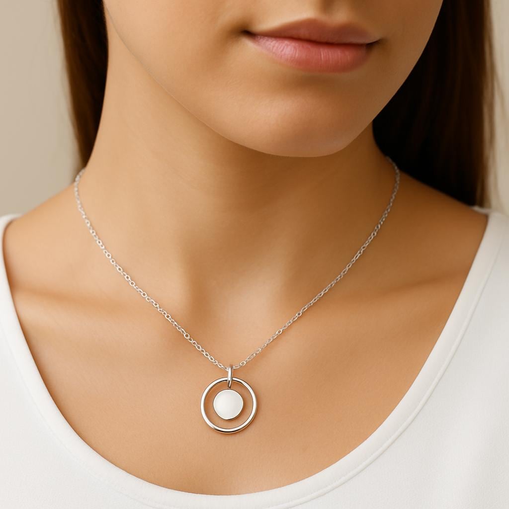 Silver necklace with a circular pendant worn by a person