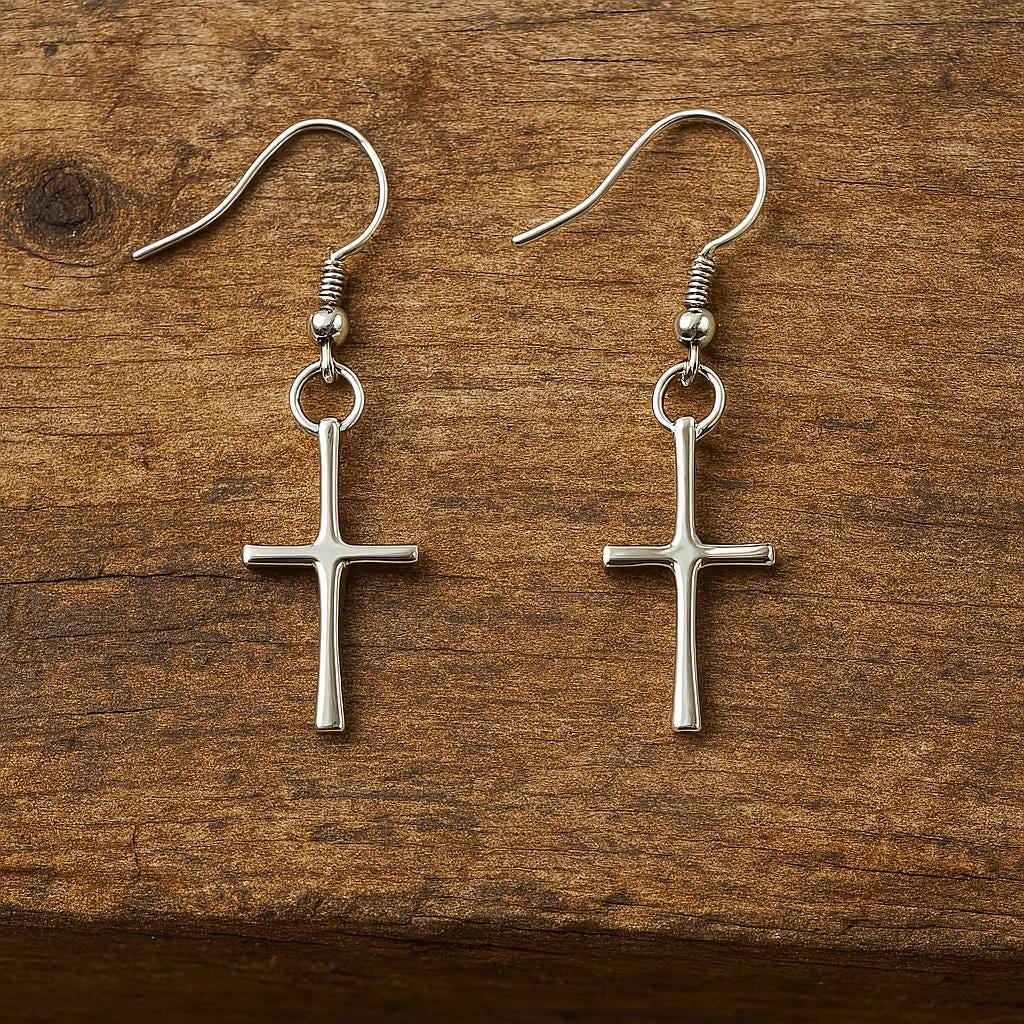 Silver cross earrings on a wooden surface