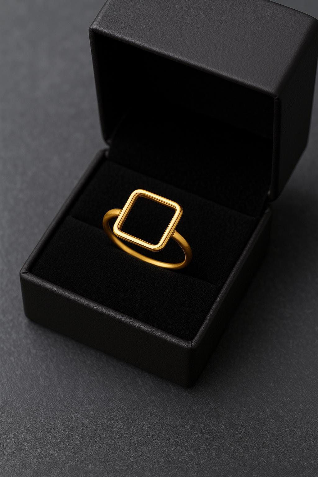 Gold ring in a black box on a dark gray background