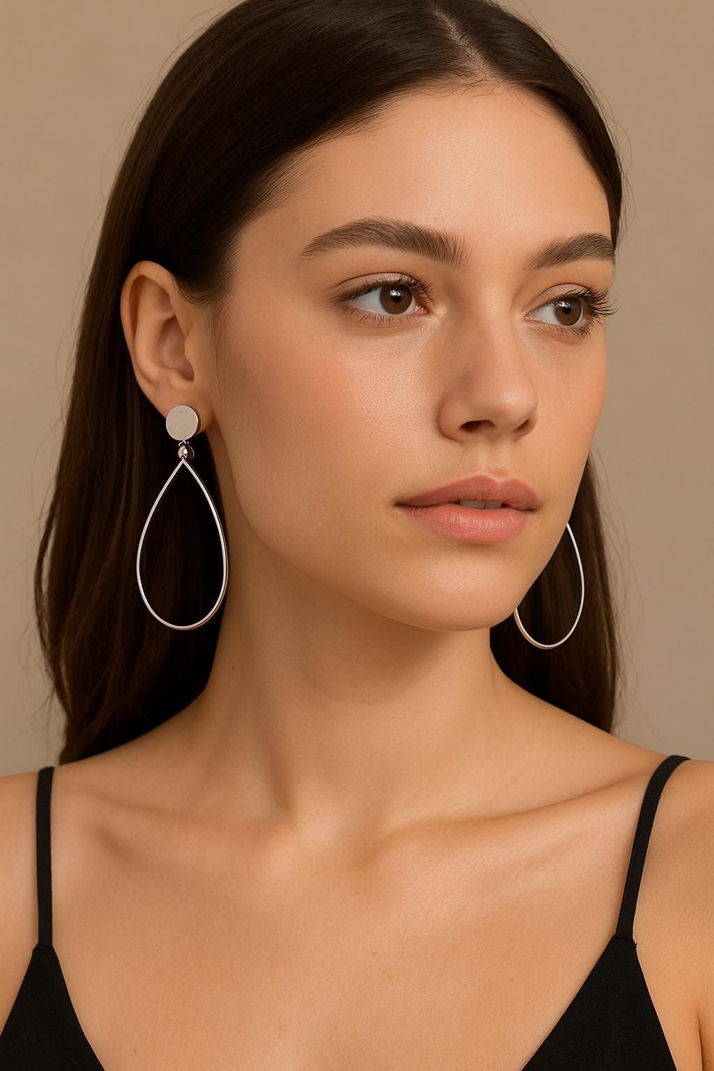 Woman wearing hoop earrings against a neutral background
