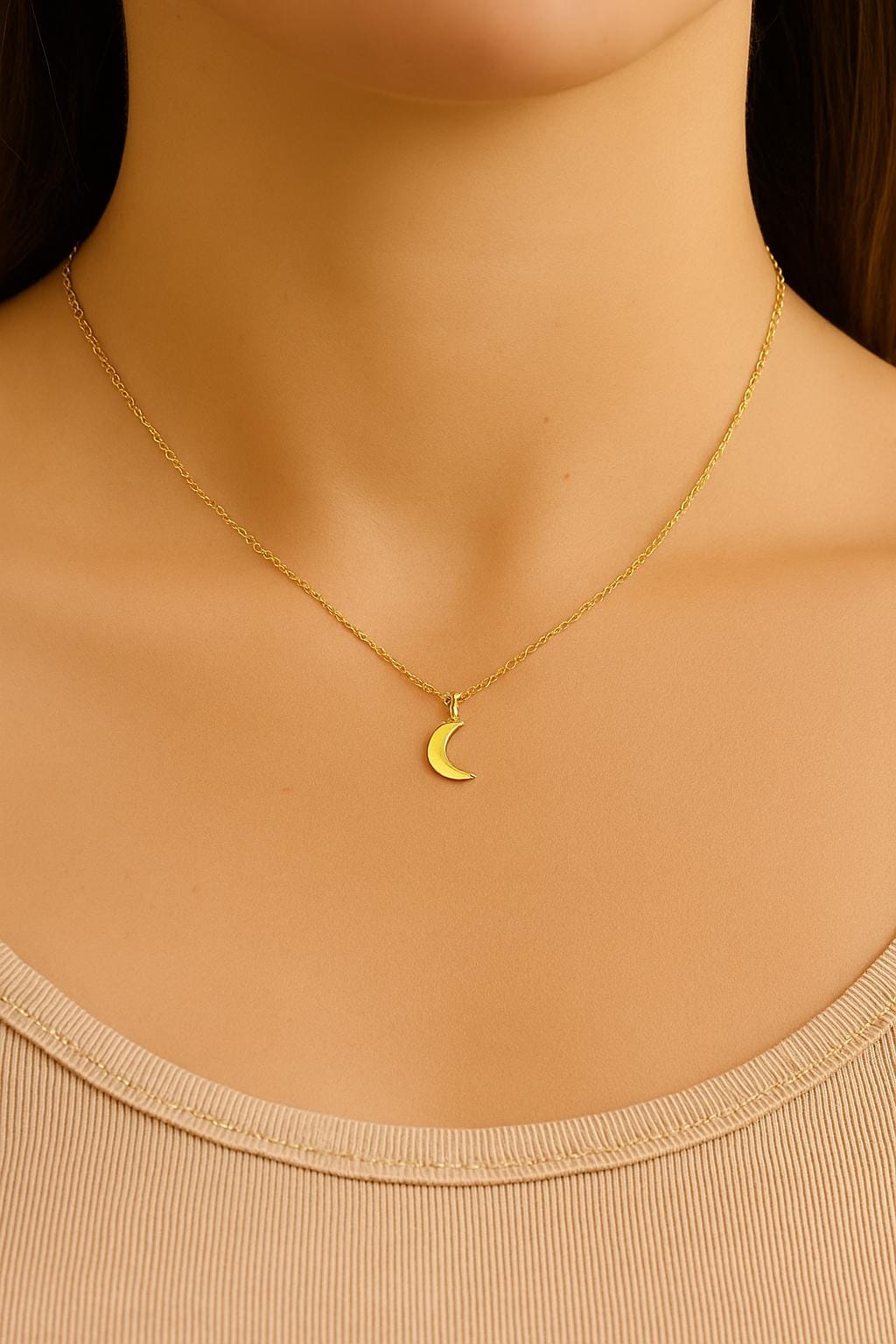 Gold necklace with a crescent moon pendant on a mannequin