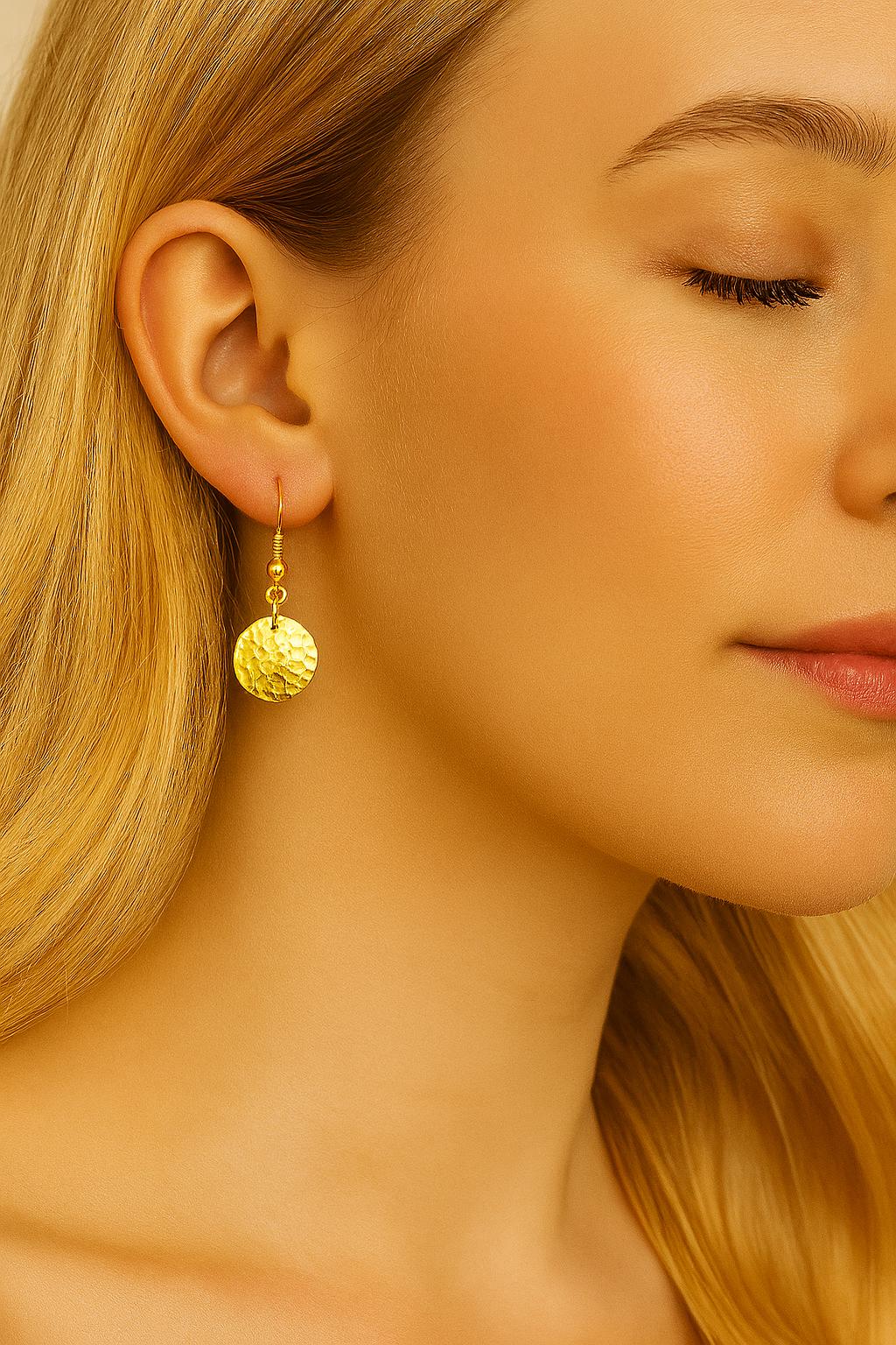 Close-up of a woman wearing gold earrings with a soft focus on her face and hair.