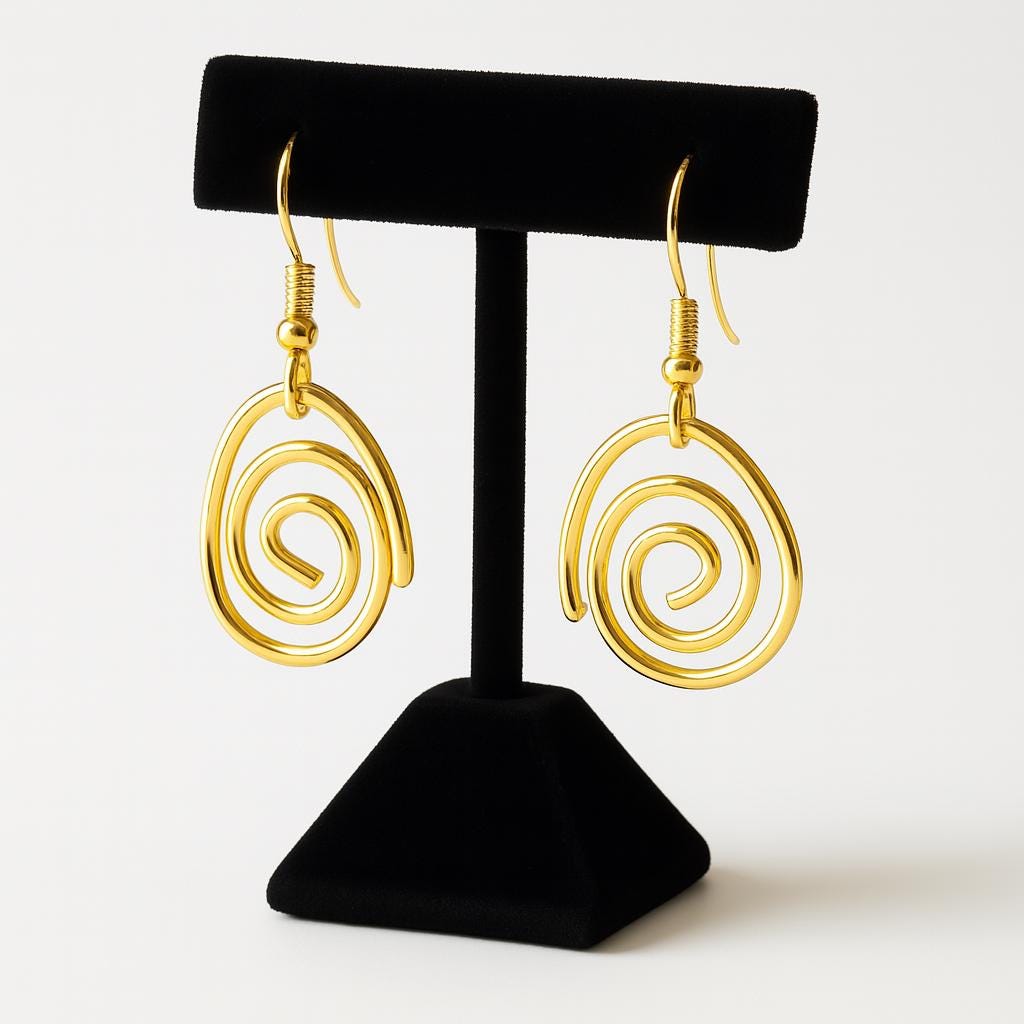 Gold spiral earrings on a black stand against a white background