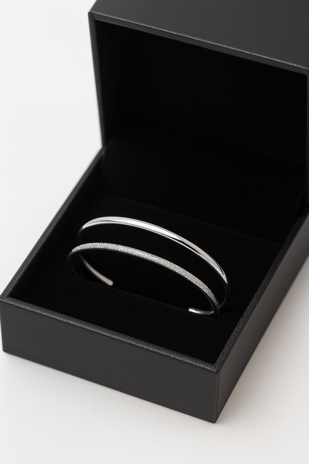 Silver bracelet in an open black jewelry box on a white background