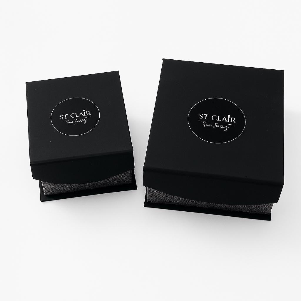 Two black jewelry boxes with 'St. Clair' branding on a white background