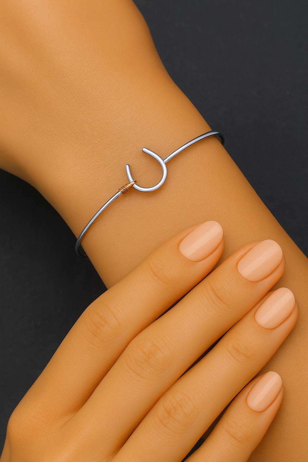 Silver bracelet on a wrist with a plain background