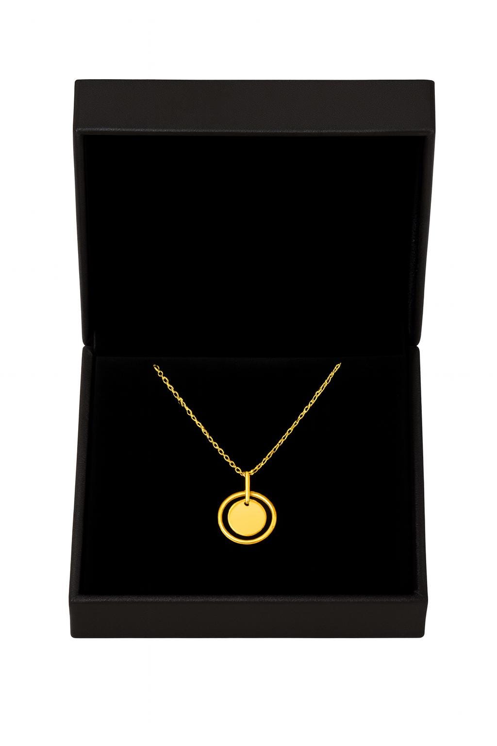 Gold necklace with a pendant in a black jewelry box on a white background