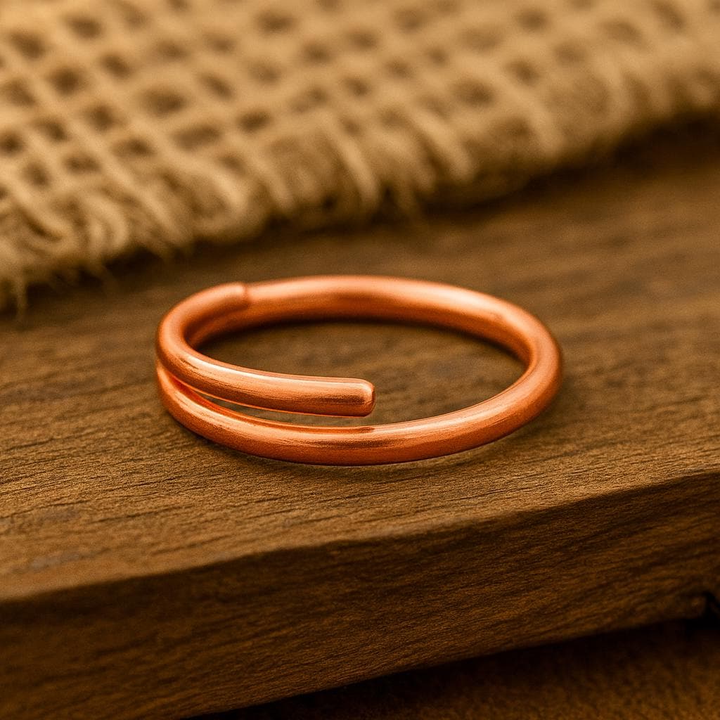 Copper bracelet on a wooden surface with a textured fabric background