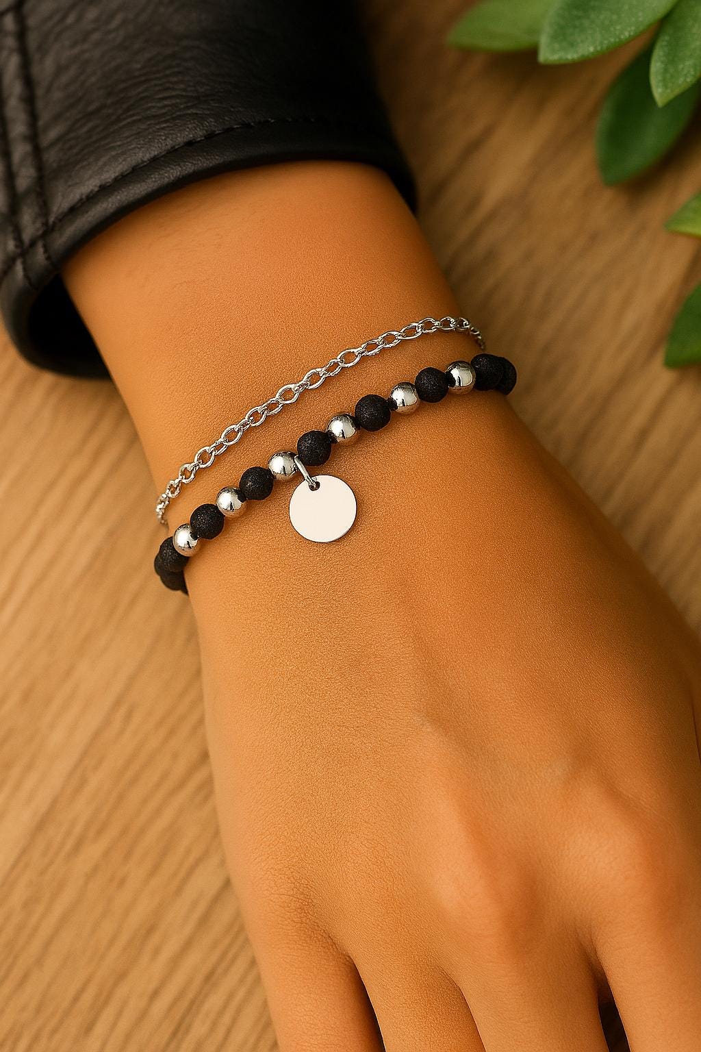 Bracelet with black and silver beads on a wrist against a wooden background