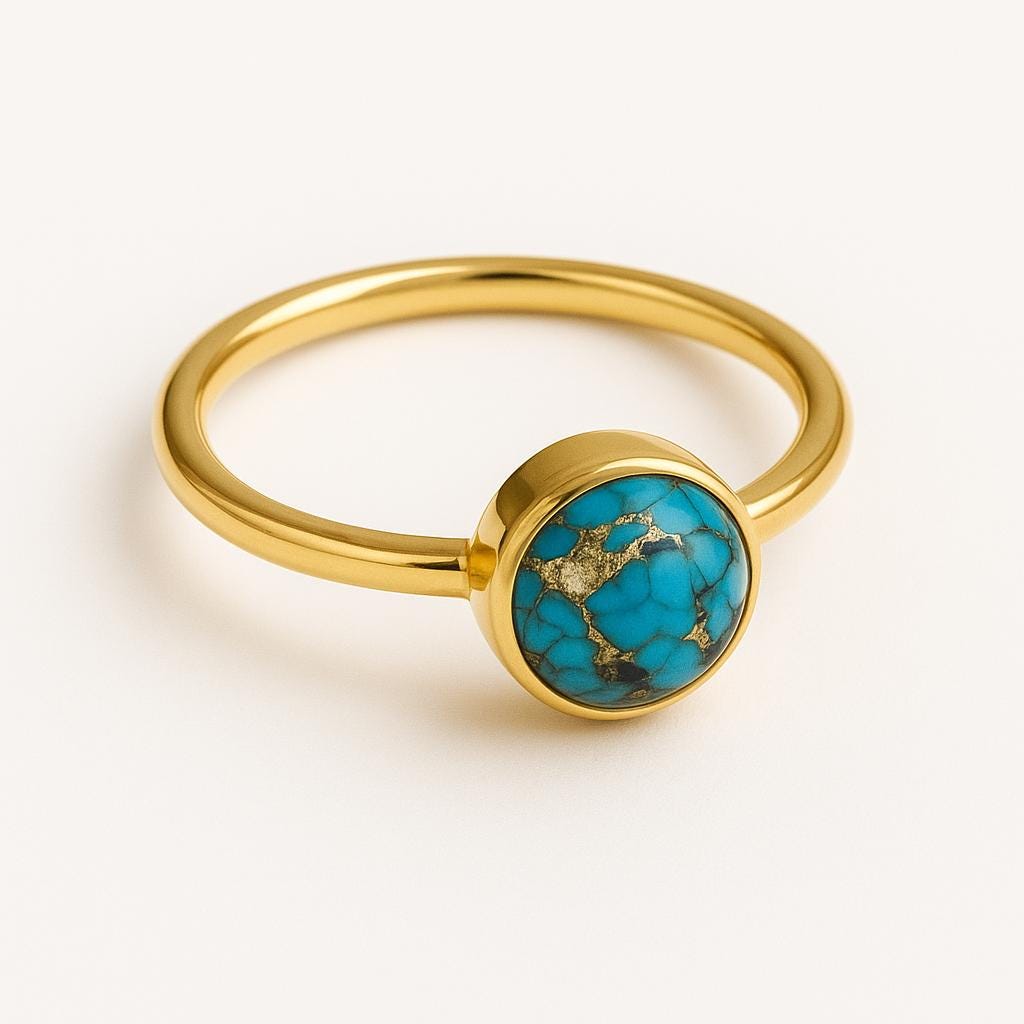 Gold ring with a turquoise stone on a white background