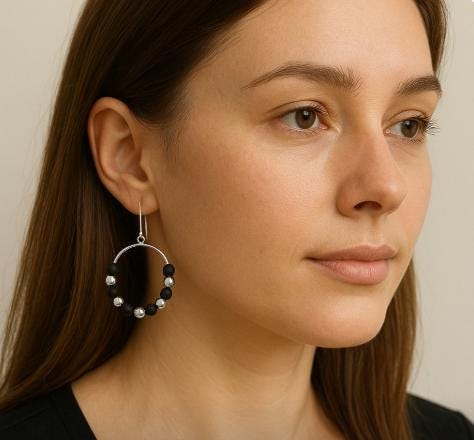 Close-up of a woman wearing a unique earring with a neutral background