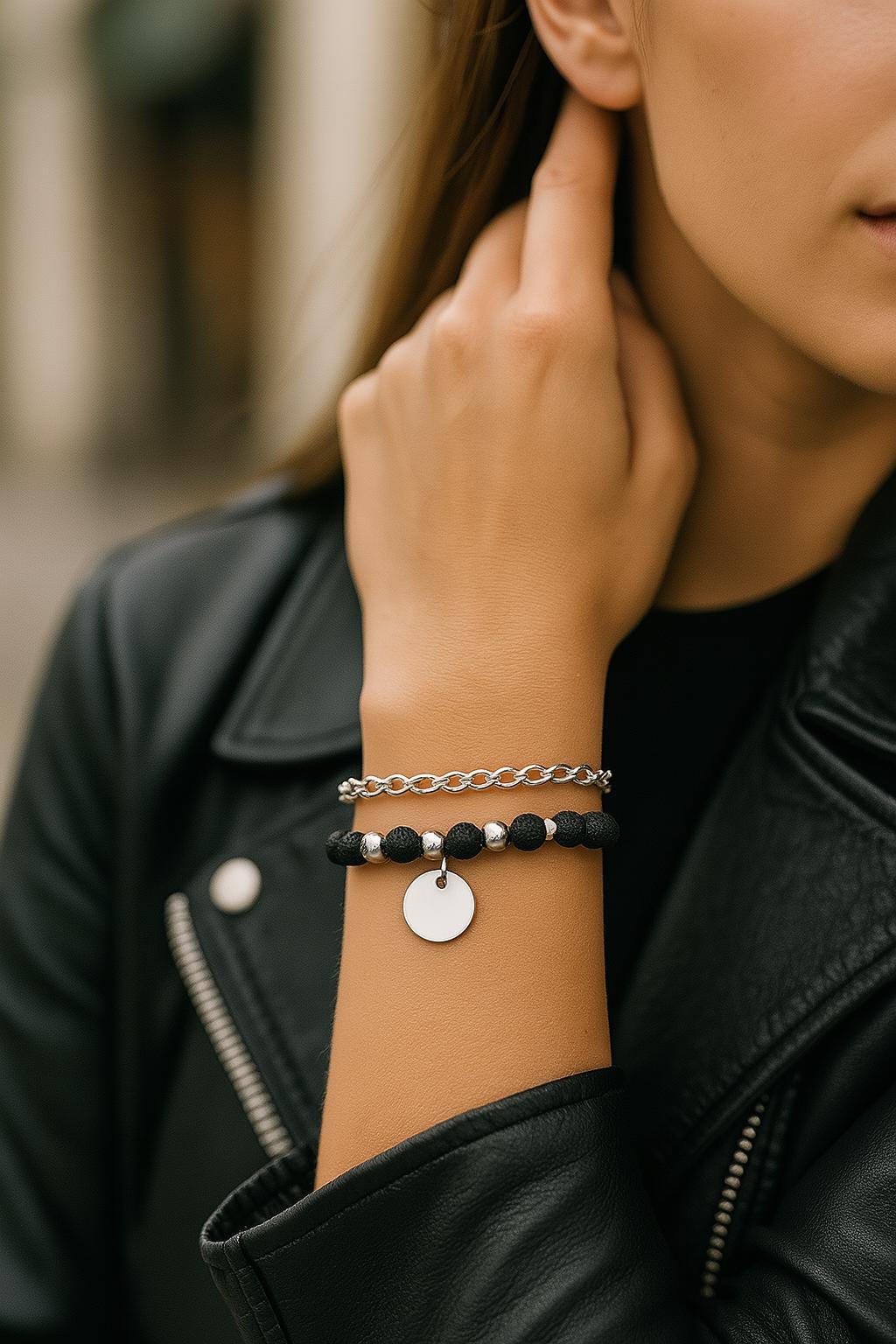 Close-up of a person wearing two bracelets on their wrist, with a blurred background.