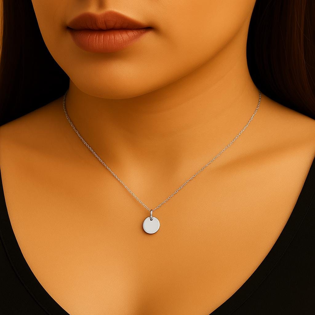 Silver necklace with a round pendant on a model against a black background