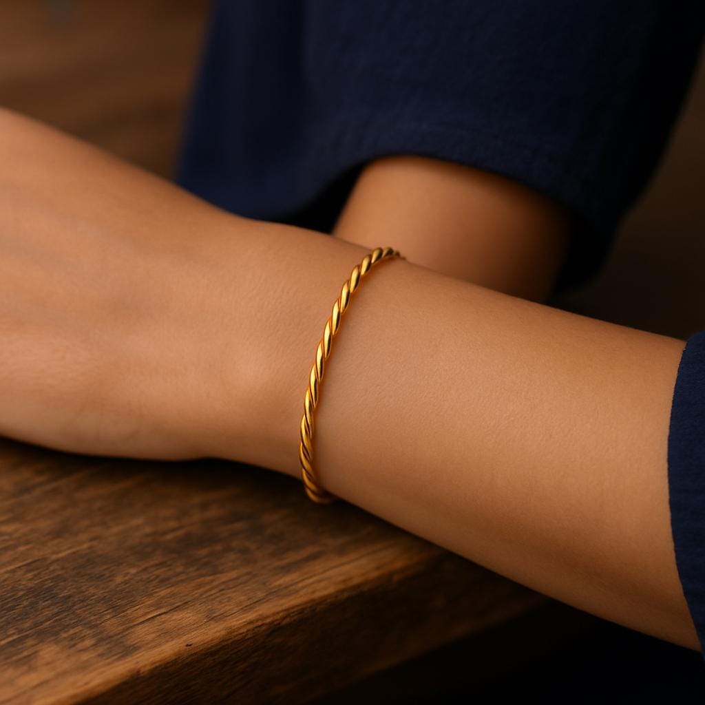 Gold bracelet on a wrist with a blurred background