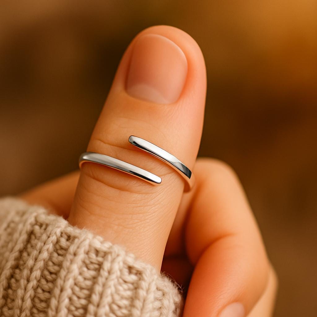 Silver ring on a finger with a blurred brown background