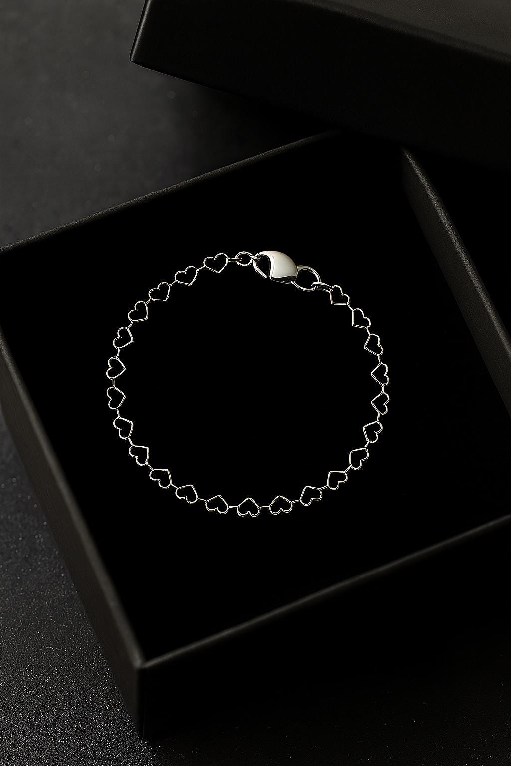 Bracelet with a moon phase design in a black box on a dark surface