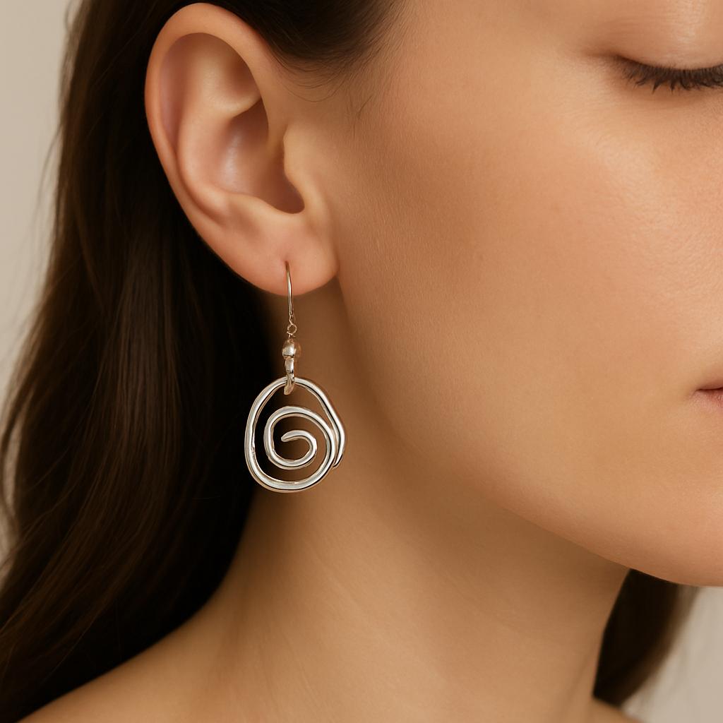 Close-up of a woman wearing a silver spiral earring against a neutral background