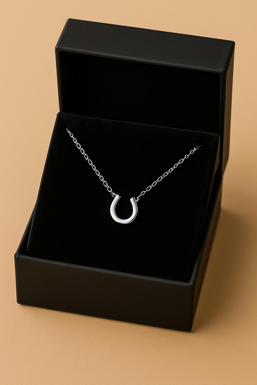 Silver necklace in a black jewelry box on a beige background