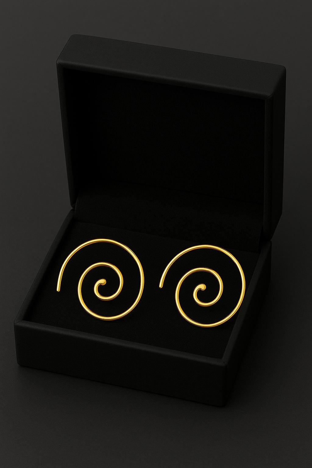 Gold spiral earrings in a black box on a dark background