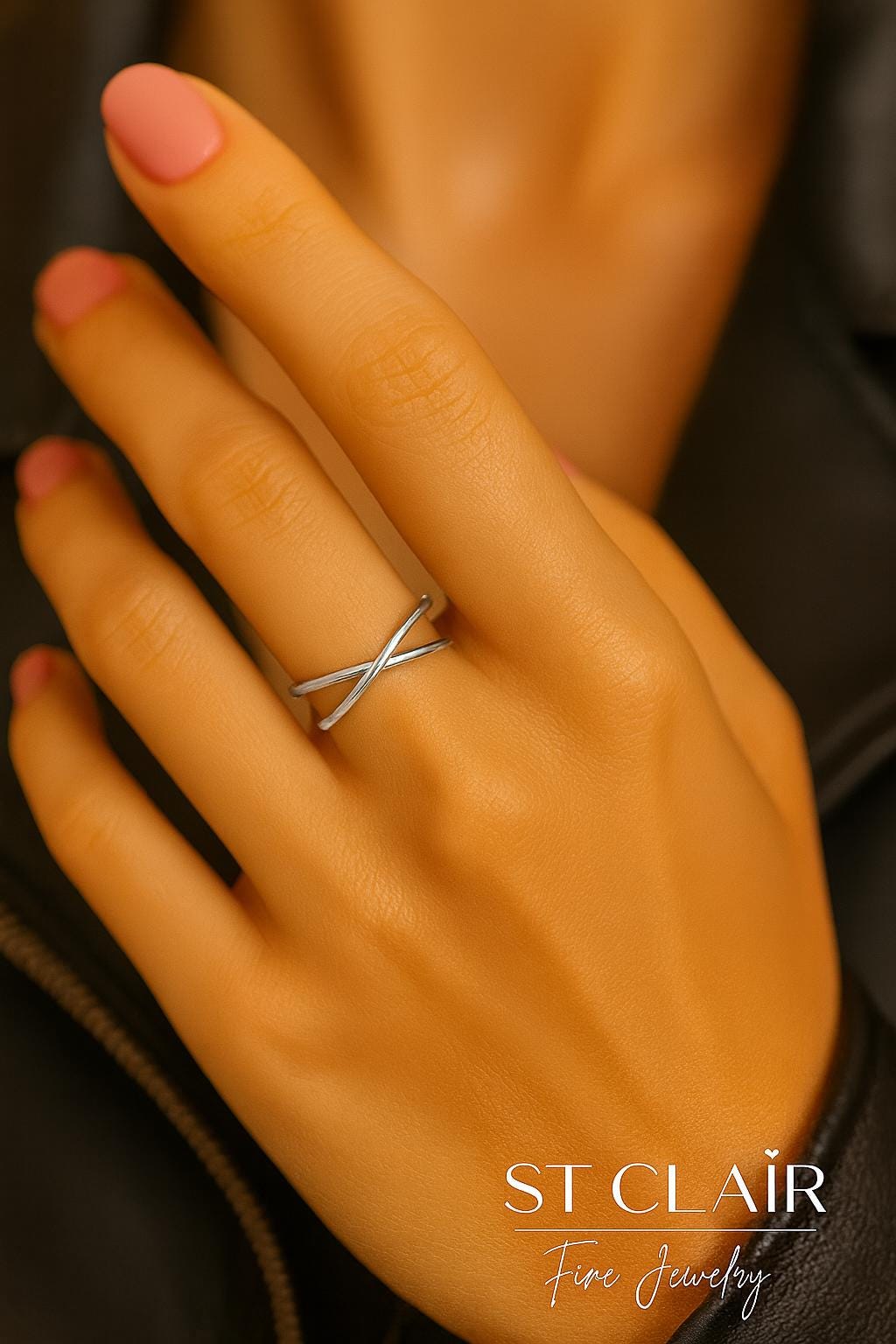 Hand wearing a silver ring with 'St. Clair Fine Jewelry' branding.