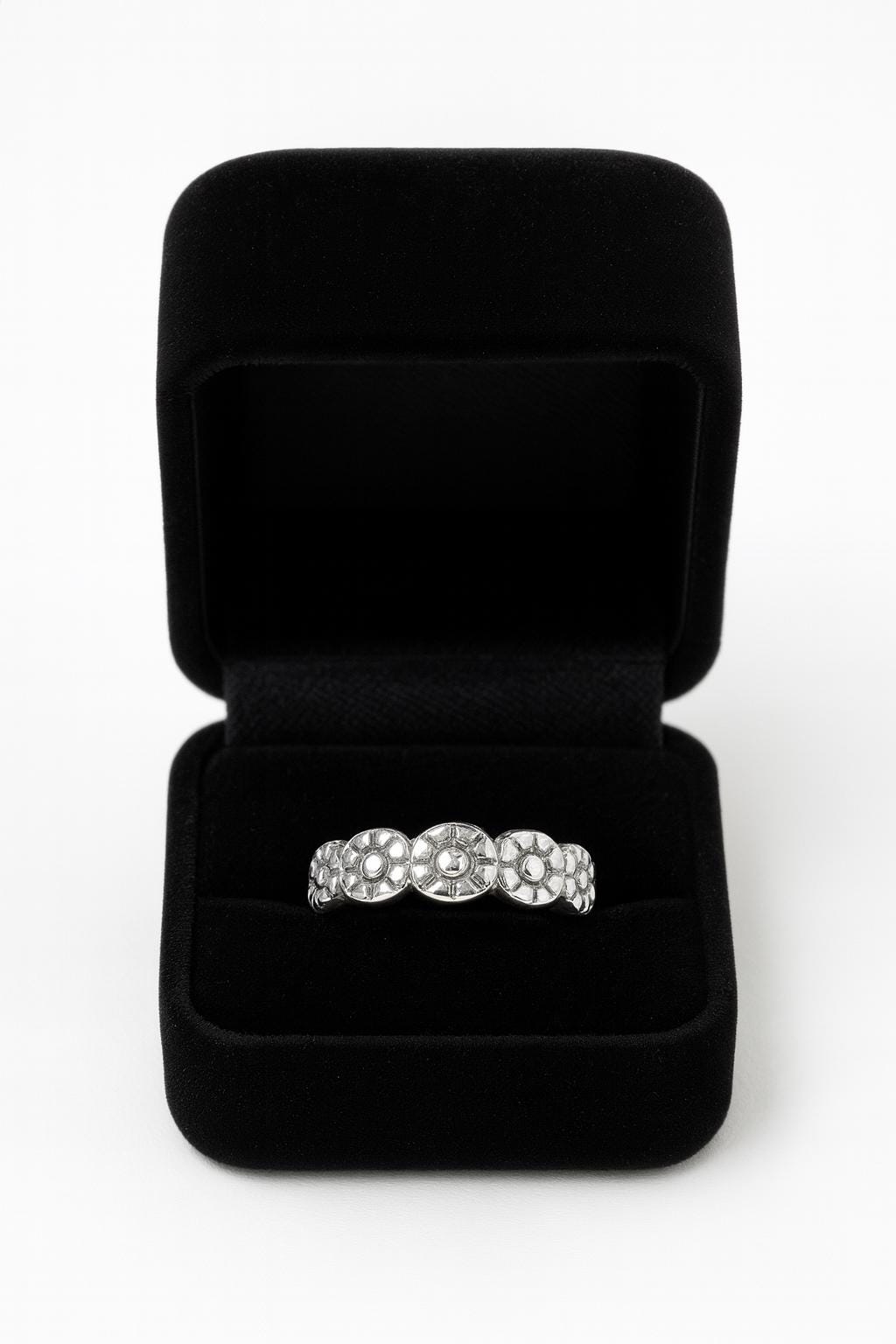 Black jewelry box with a silver ring featuring pearls on a white background