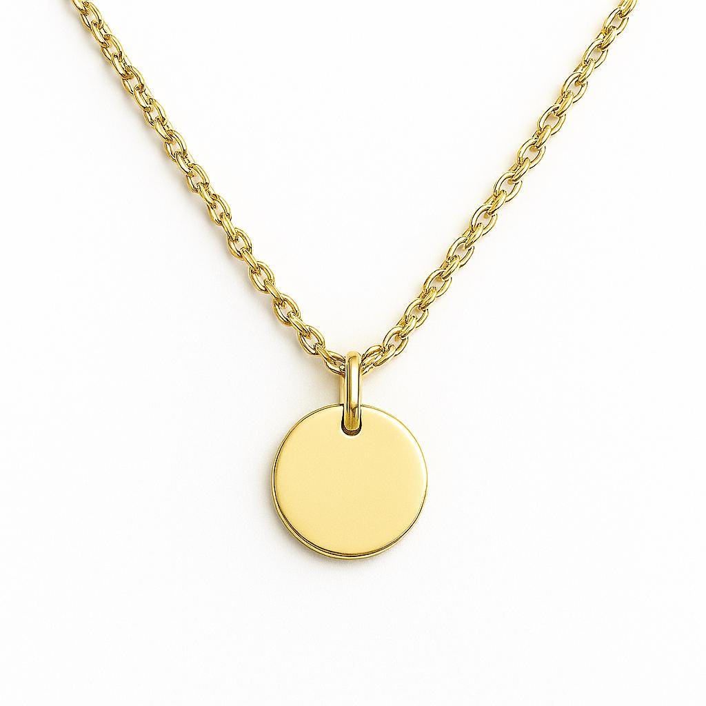 Gold necklace with a round pendant on a white background
