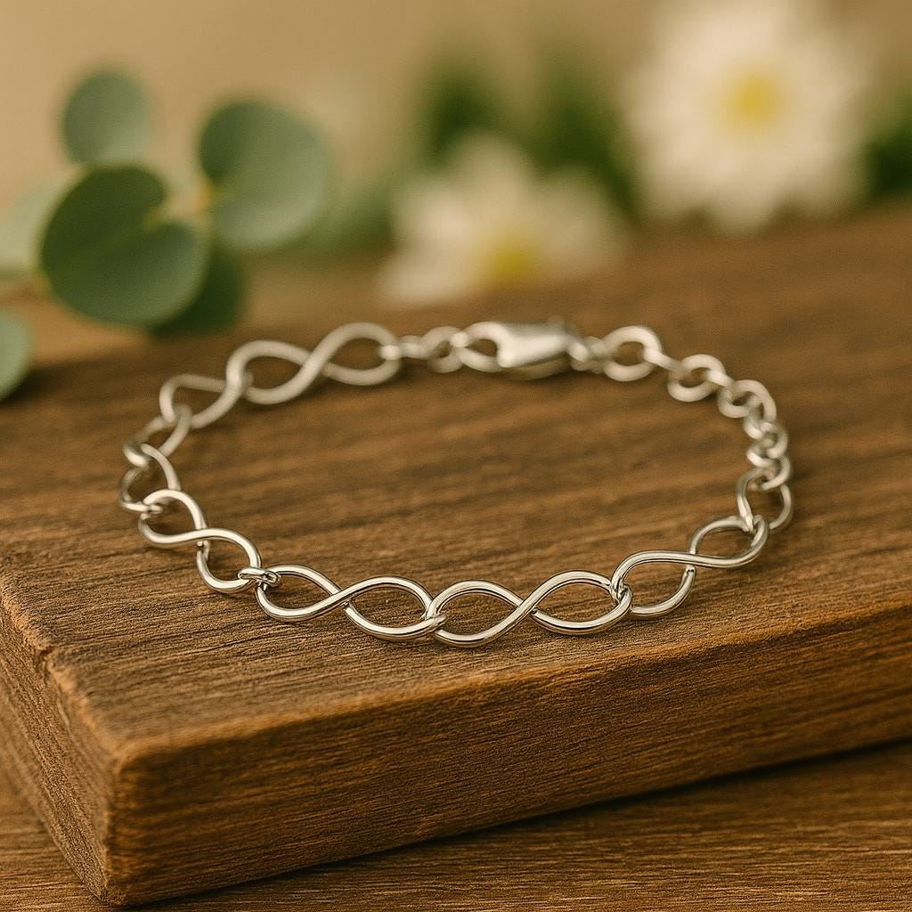 Silver bracelet on a wooden surface with blurred greenery in the background