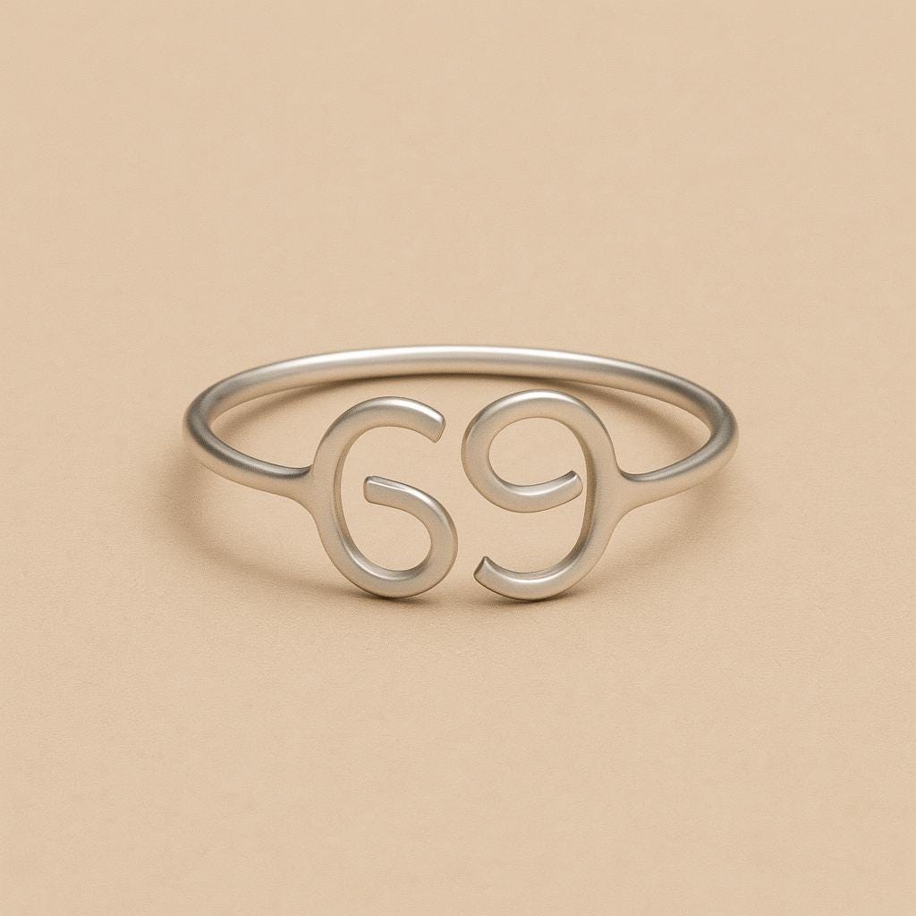 Silver ring with the number '69' on a beige background