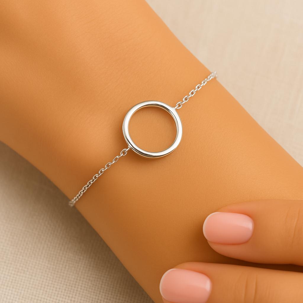 Silver bracelet with a circular design on a wrist against a beige background