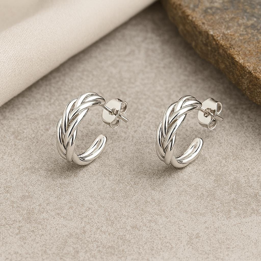 Pair of silver hoop earrings on a textured surface