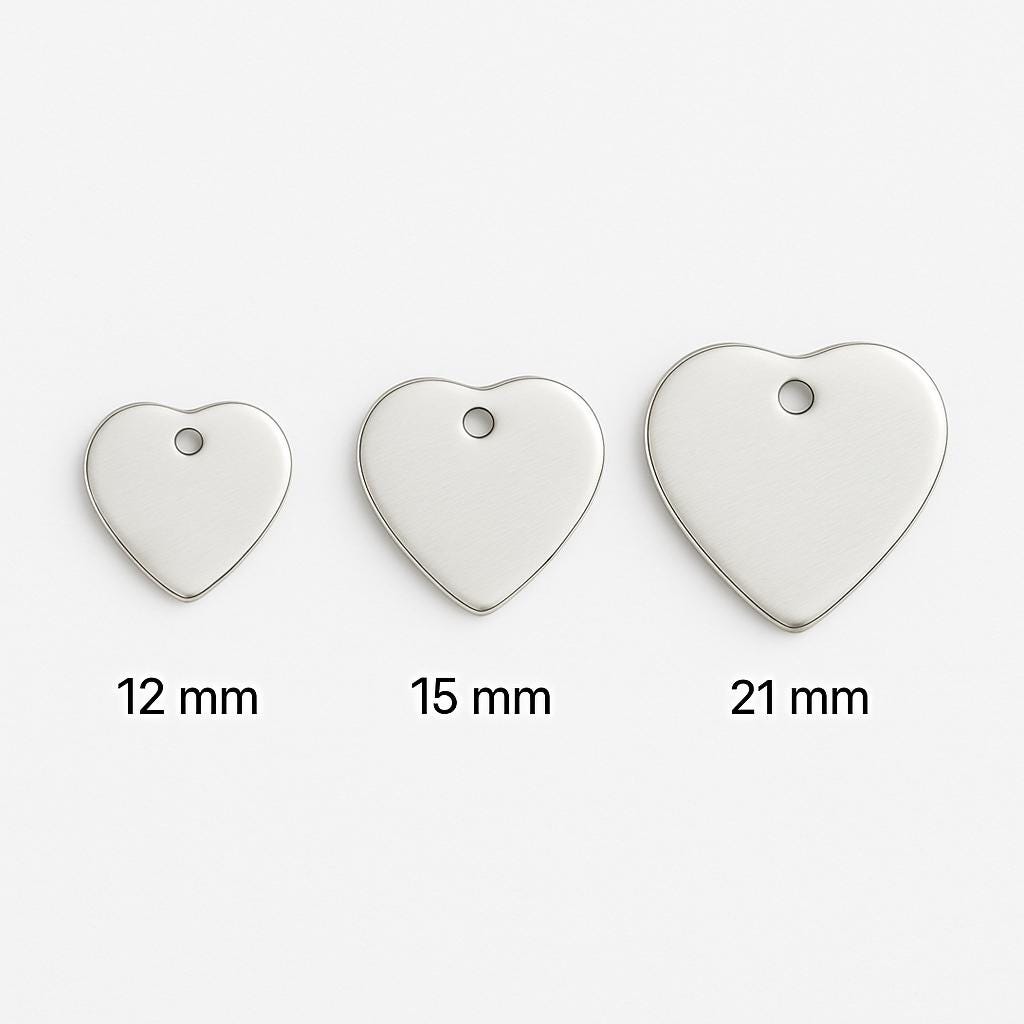 Three heart-shaped metal tags of different sizes on a white background