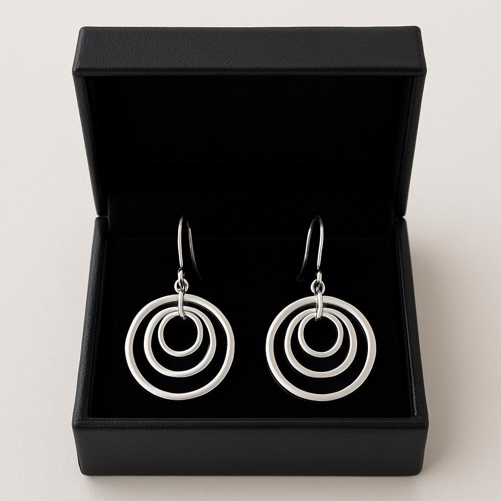 Silver circle earrings in a black jewelry box on a light gray background