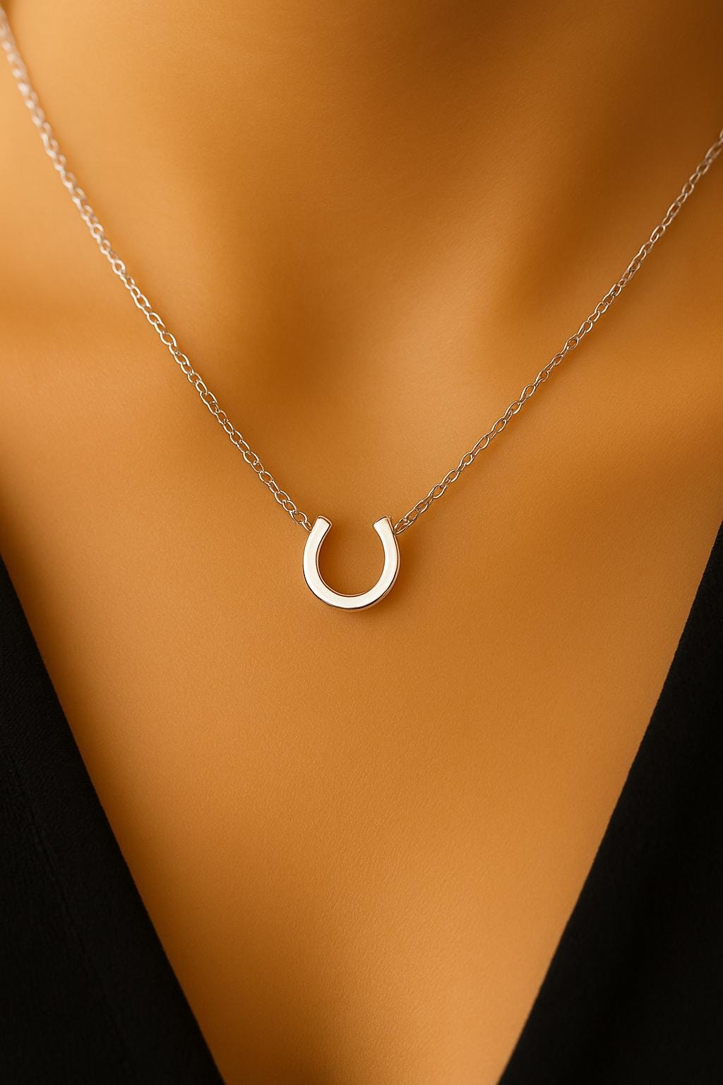 Silver horseshoe necklace on a mannequin with a brown background