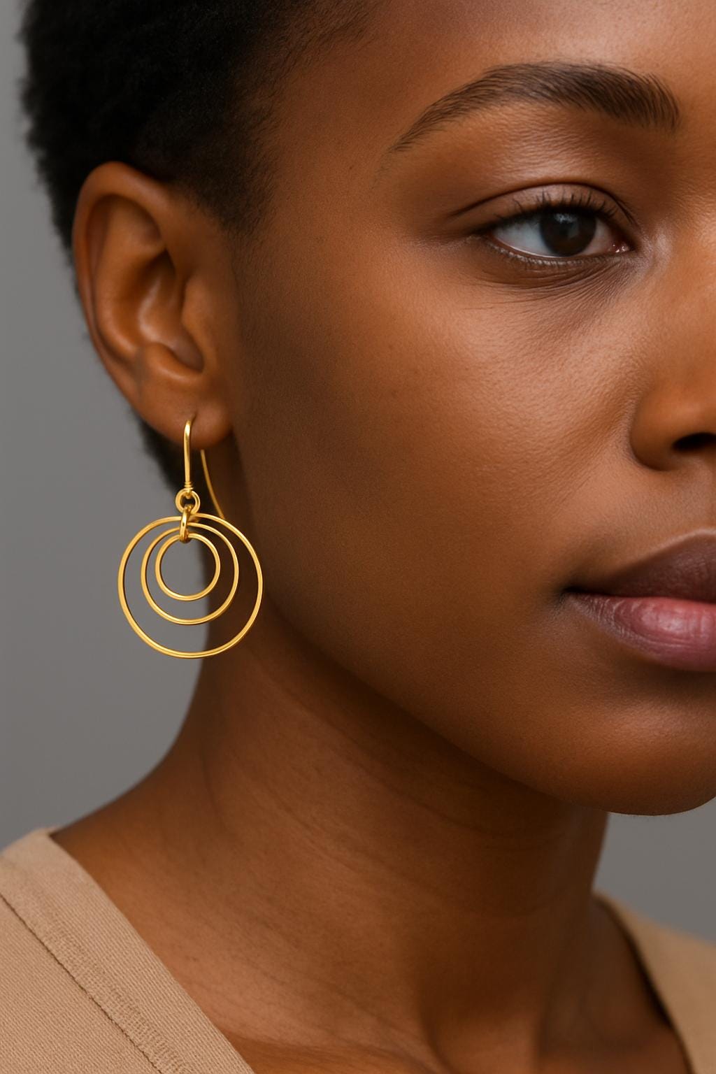 Gold Brass Dangle earrings on a textured surface with a black box in the background