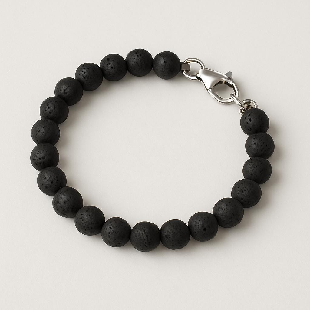Black beaded bracelet with a silver clasp on a light gray background