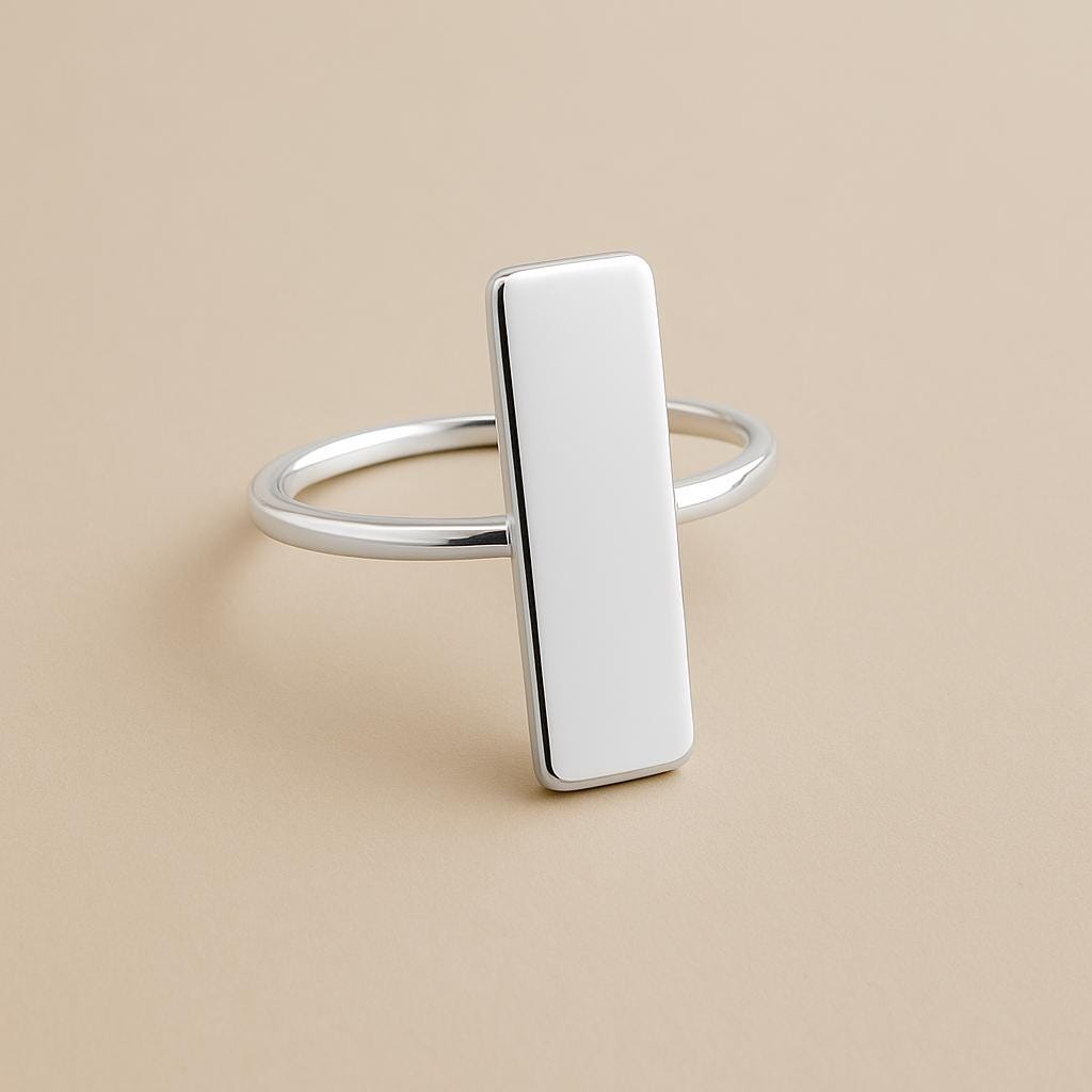 Silver ring with a rectangular pendant on a beige background