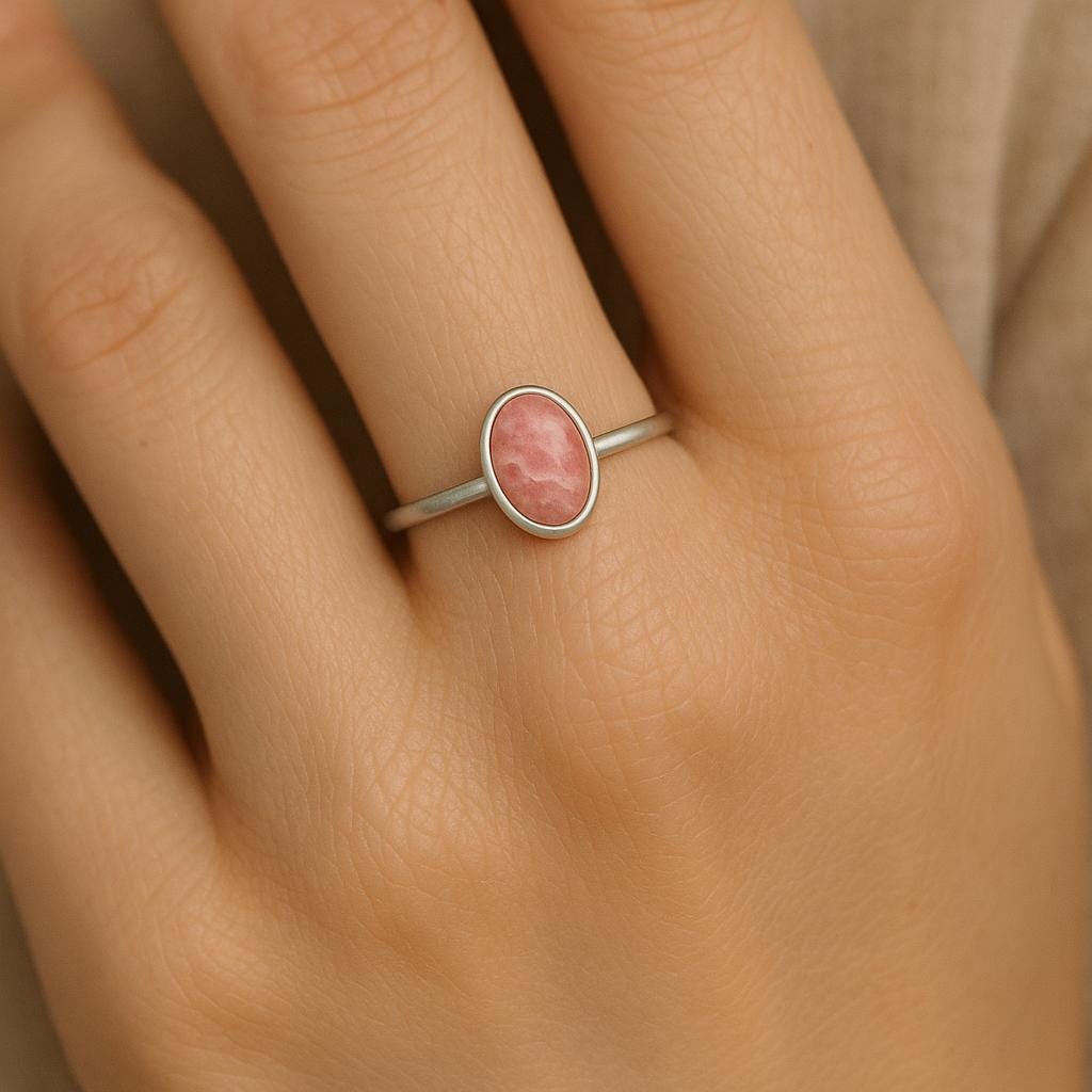 Silver ring with a pink stone on a hand