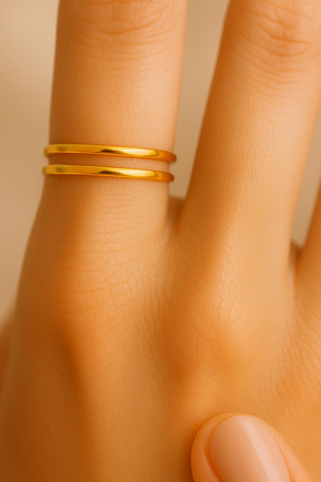 Gold ring on a person's finger with a neutral background