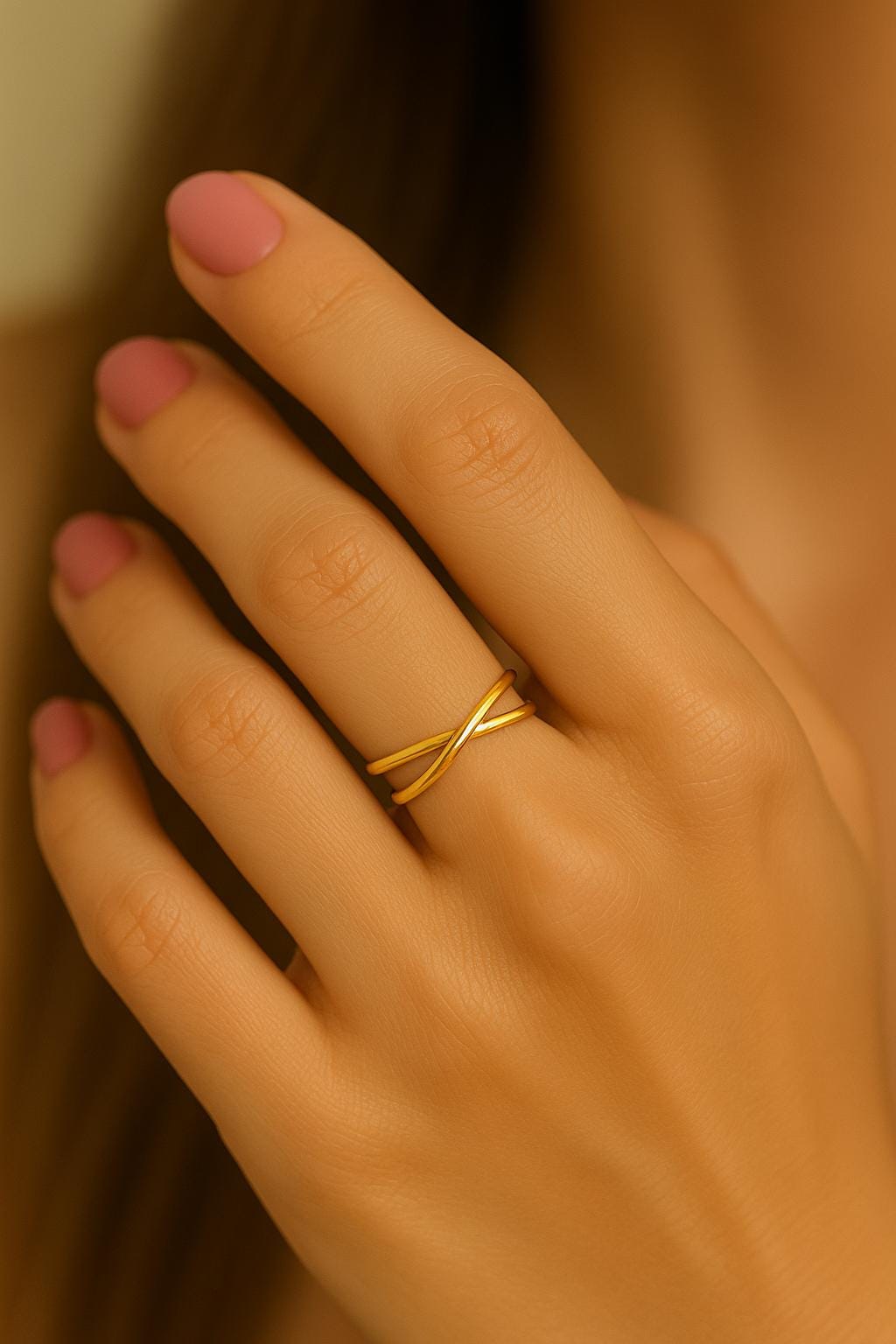 Hand wearing a gold ring with a blurred background