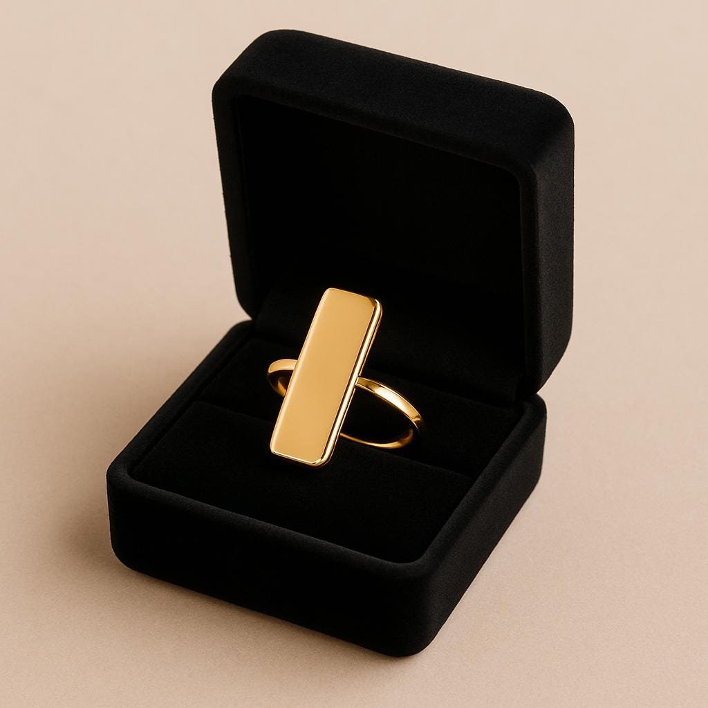 Gold ring in a black jewelry box on a beige background