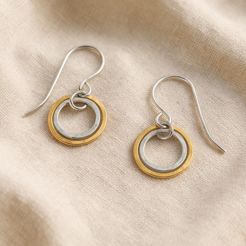 Pair of earrings with two-toned rings on a beige fabric background