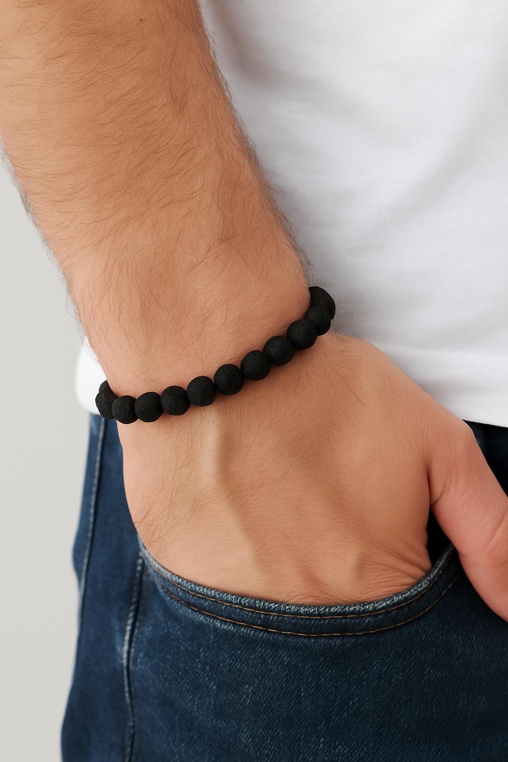 Black beaded bracelet on a wrist with a white shirt and jeans background