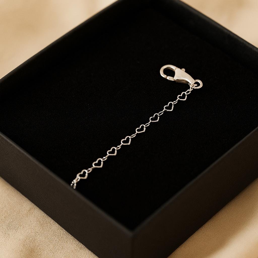 Silver bracelet with heart-shaped links on a black box
